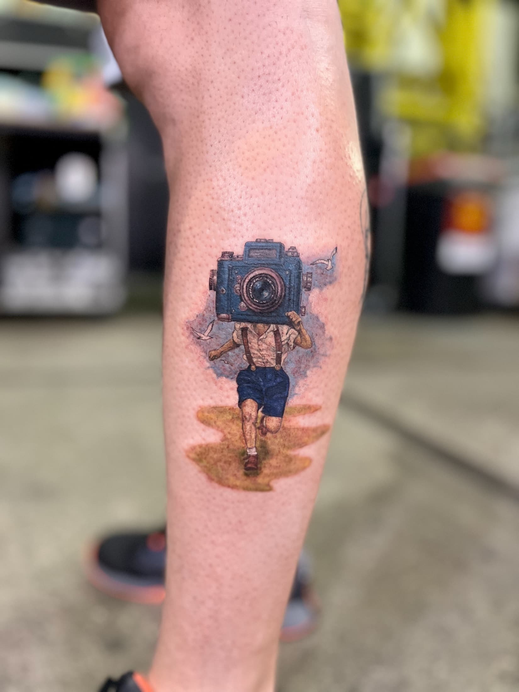 Color tattoo of a camera character on the forearm