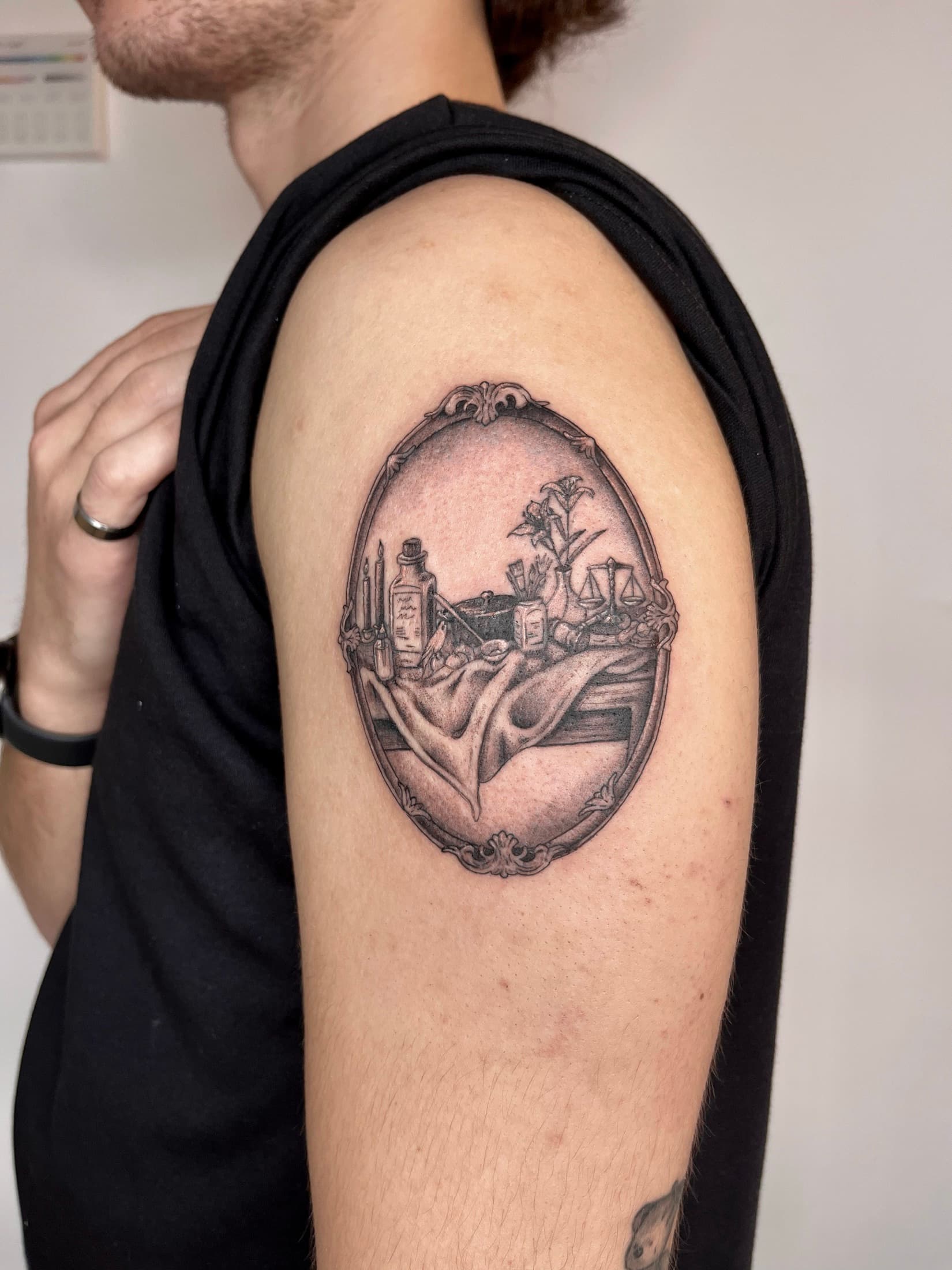 Framed apothecary scene tattoo on the upper arm